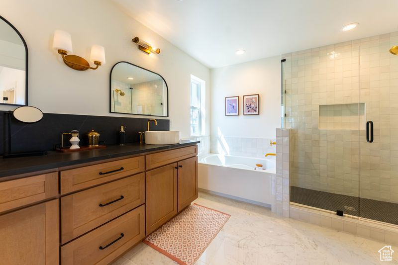 Bathroom featuring dual vanity, separate shower and tub, and tile floors