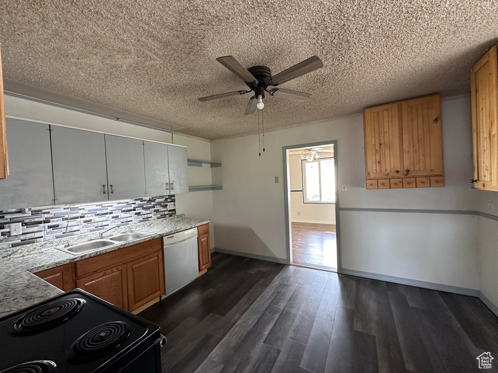 Kitchen featuring backsplash, ceiling fan, dishwasher, stove, and dark hardwood / wood-style floors