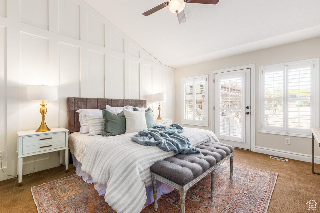 Carpeted bedroom with vaulted ceiling, ceiling fan, and access to exterior