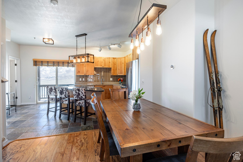 Dining room with sink, track lighting, and dark hardwood / wood-style floors