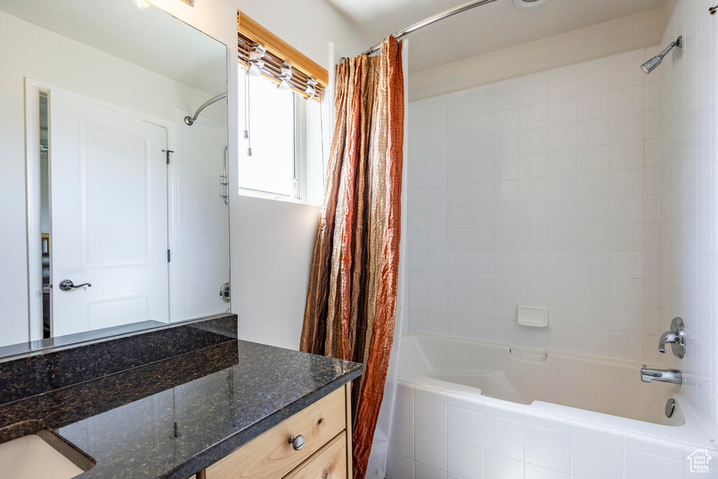 Bathroom featuring vanity and shower / bath combination with curtain