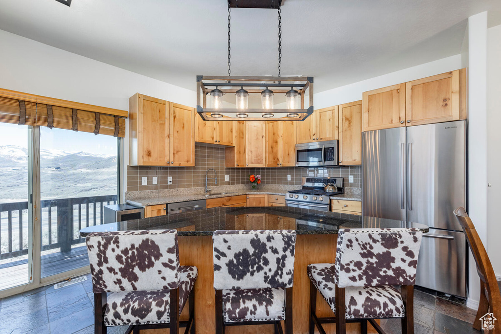 Kitchen featuring a kitchen island, plenty of natural light, tasteful backsplash, and stainless steel appliances