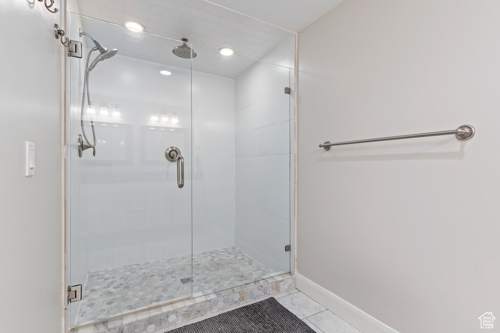 Bathroom featuring tile floors and a shower with shower door