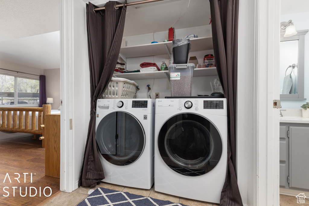 Laundry room featuring separate washer and dryer, light hardwood / wood-style floors, and washer hookup