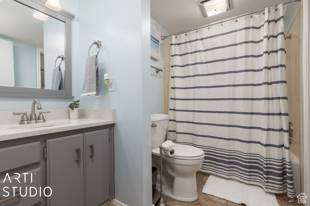 Full bathroom with shower / bath combo with shower curtain, toilet, tile flooring, and vanity