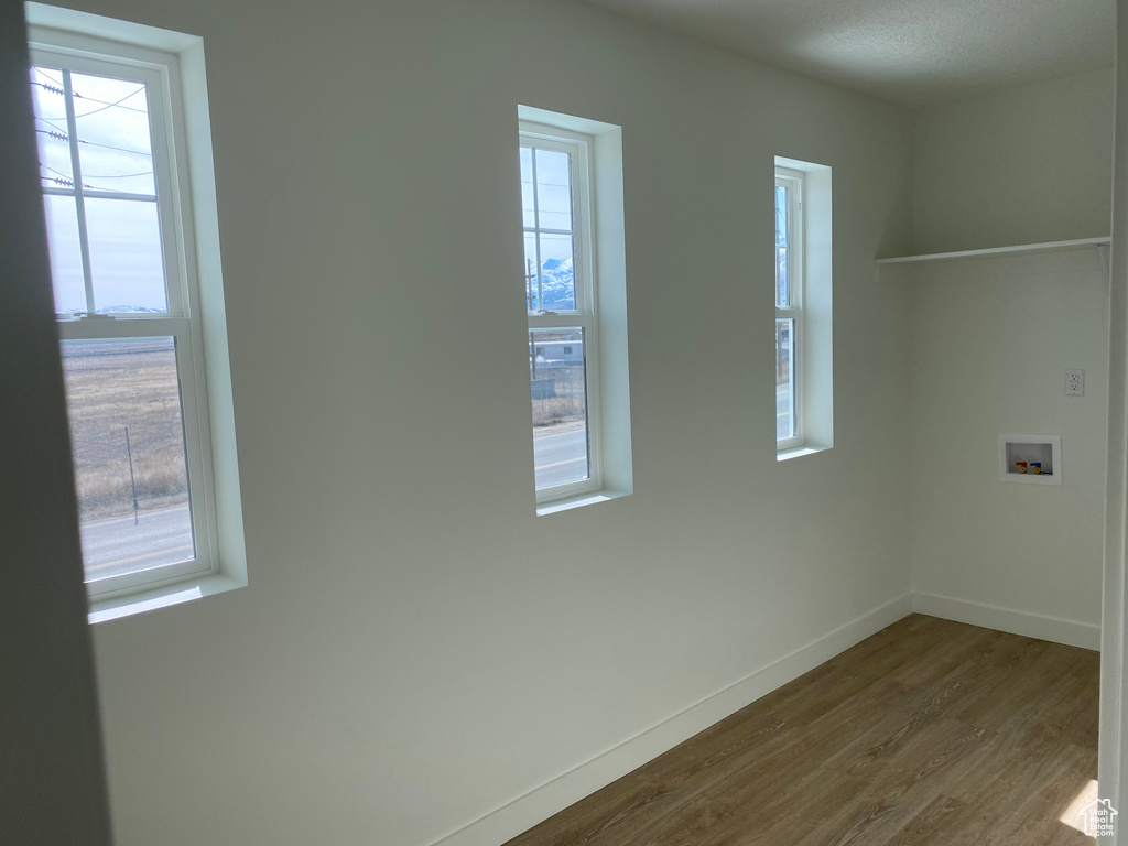 Spare room with dark hardwood / wood-style floors and a wealth of natural light