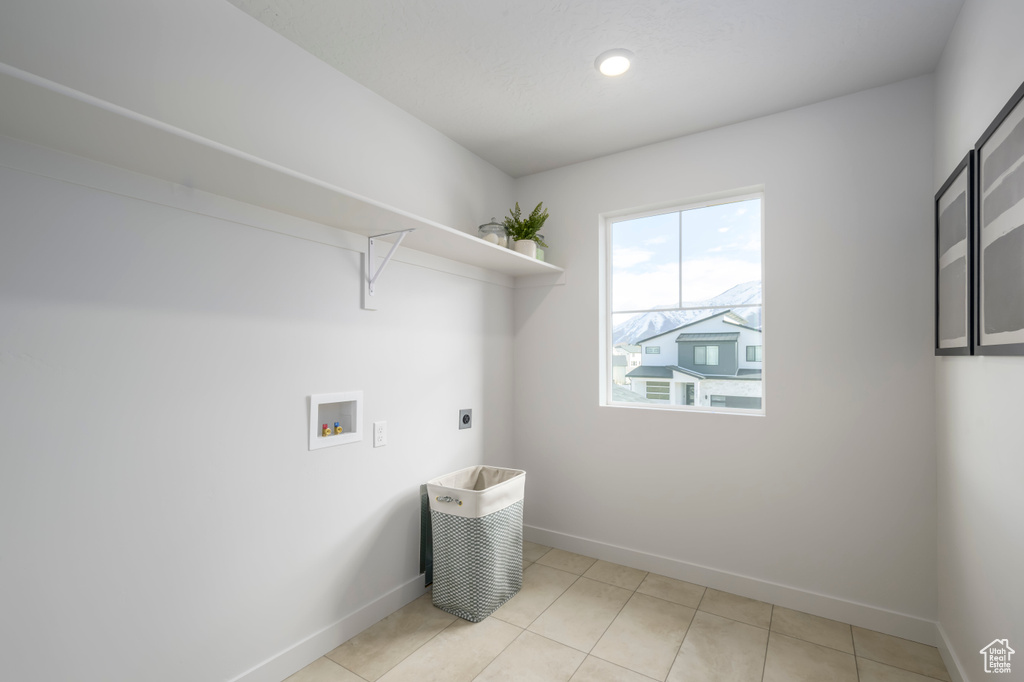 Washroom with washer hookup, light tile floors, and electric dryer hookup