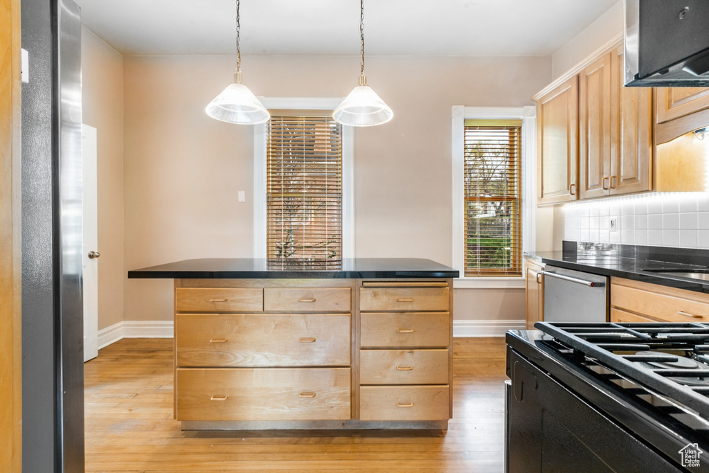 Kitchen with backsplash, light hardwood / wood-style flooring, light brown cabinetry, pendant lighting, and stainless steel dishwasher