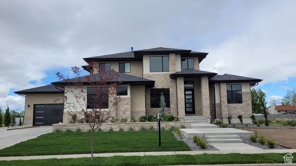 Prairie-style home with a front yard and a garage