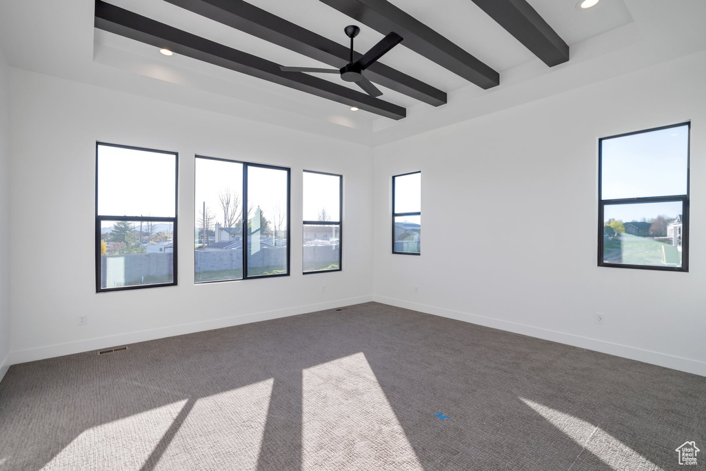 Carpeted spare room with beam ceiling and ceiling fan