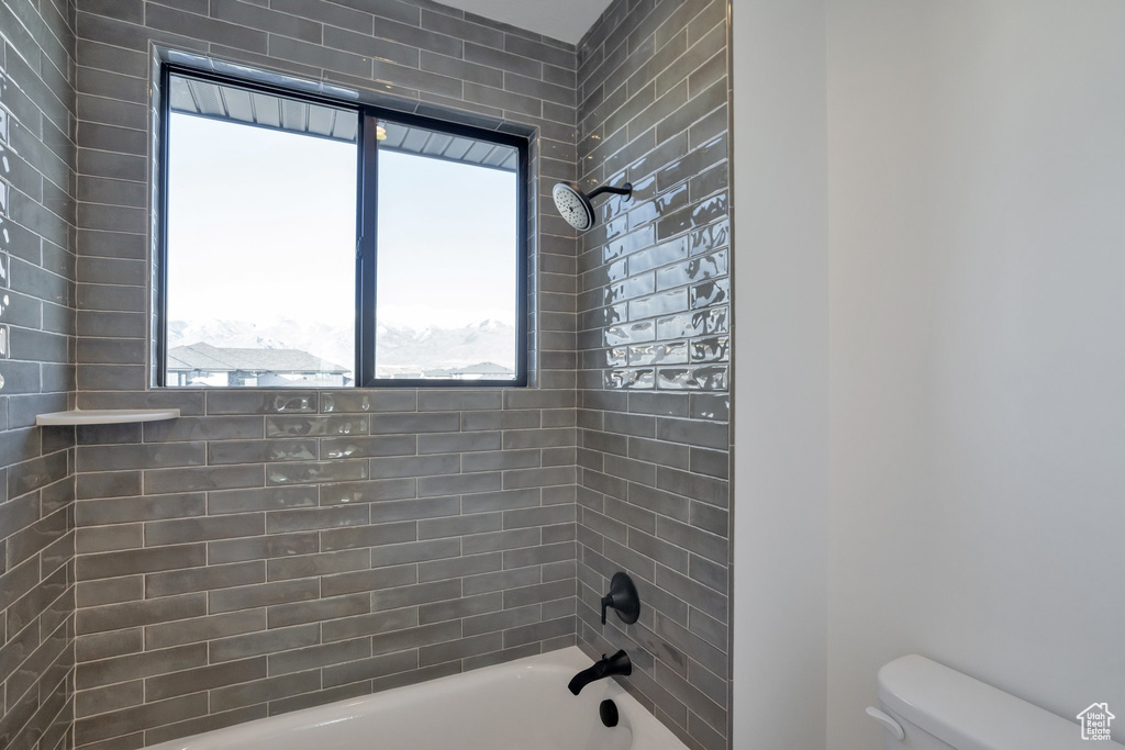 Bathroom featuring toilet and tiled shower / bath combo