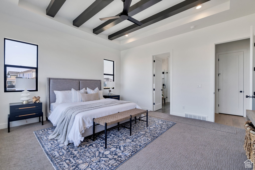 Bedroom with light colored carpet, ceiling fan, and beam ceiling