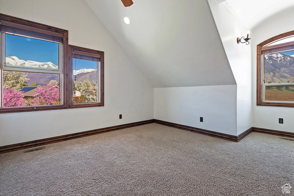 Additional living space featuring lofted ceiling, carpet floors, and ceiling fan
