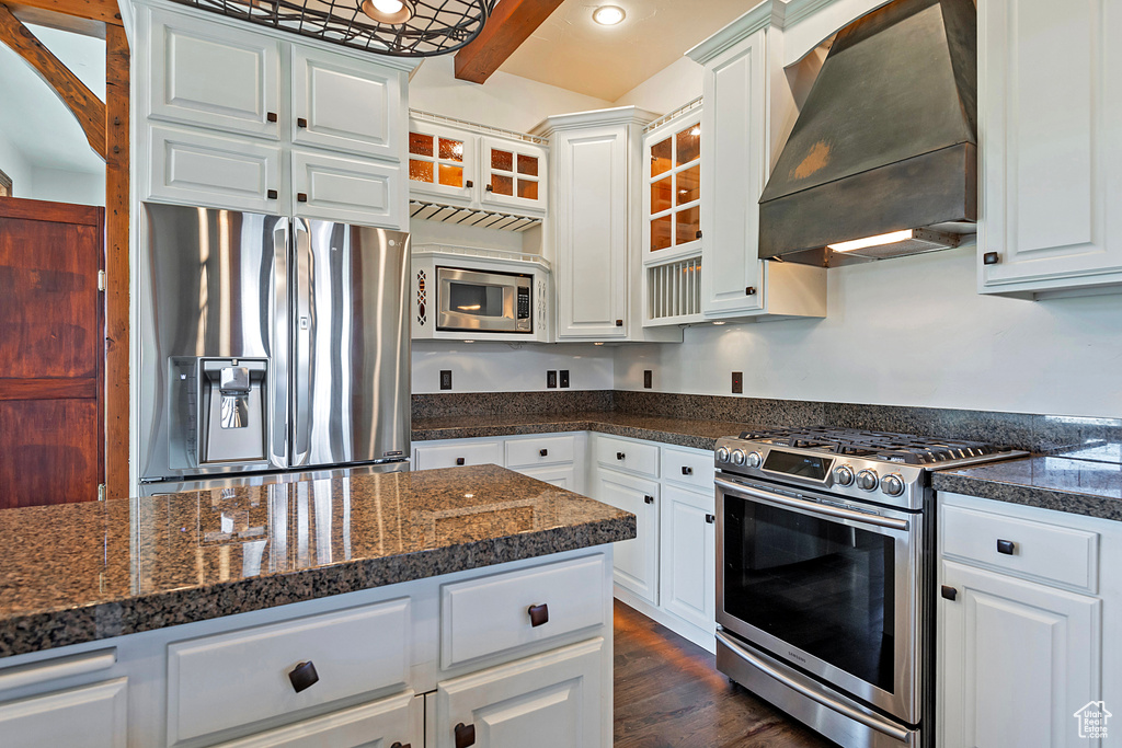 Kitchen featuring dark hardwood / wood-style floors, custom exhaust hood, stainless steel appliances, and white cabinets