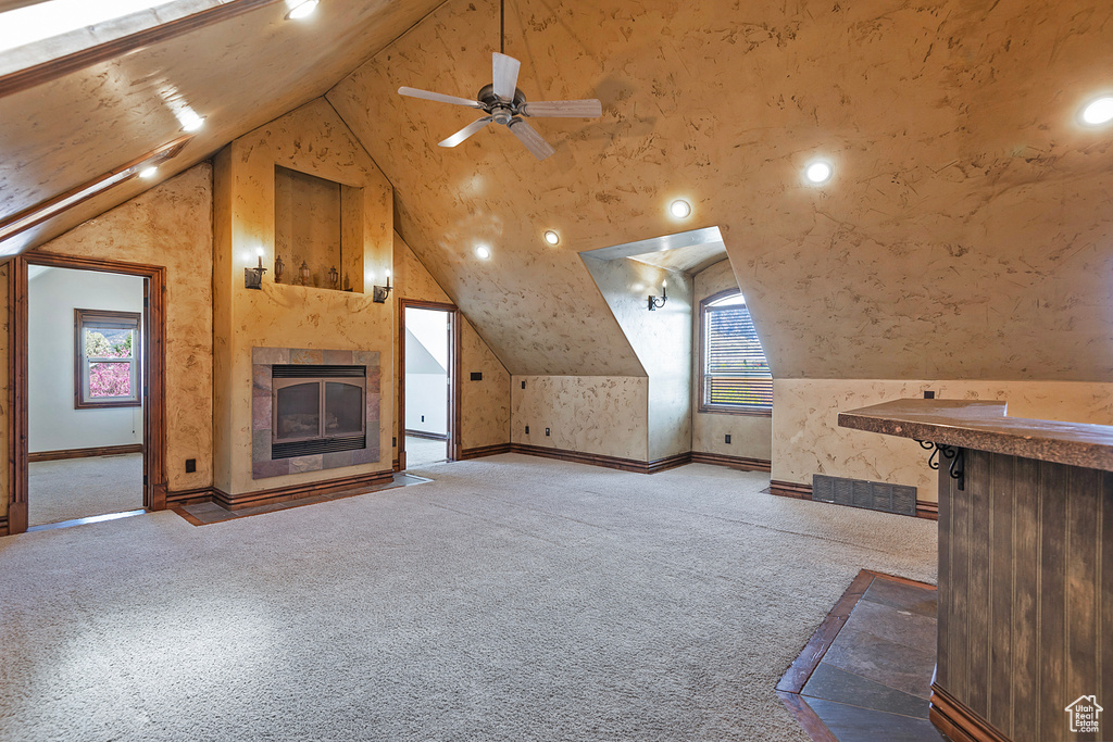 Bonus room with plenty of natural light, light carpet, ceiling fan, and vaulted ceiling