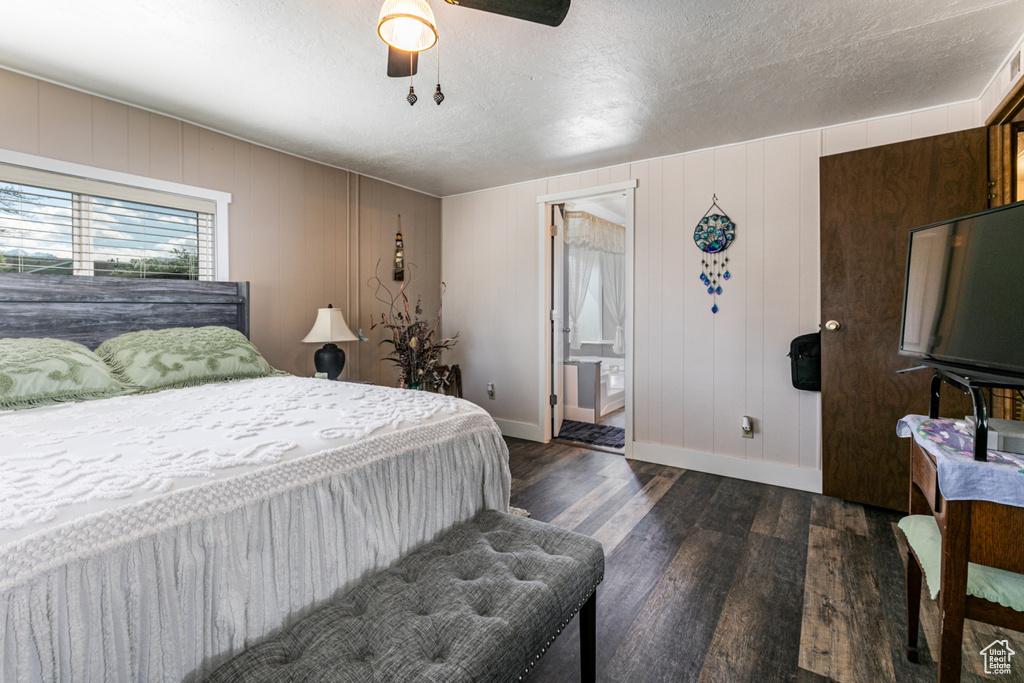 Bedroom with ceiling fan, dark hardwood / wood-style flooring, ensuite bathroom, and a textured ceiling
