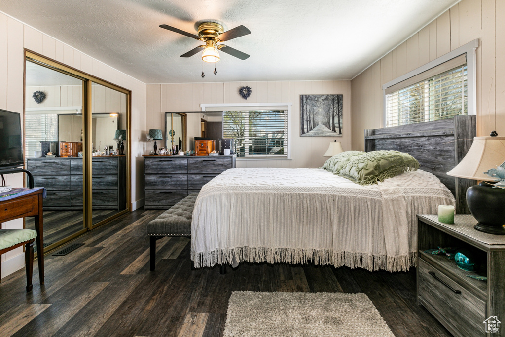 Bedroom with dark wood-type flooring, ceiling fan, a closet, and a textured ceiling