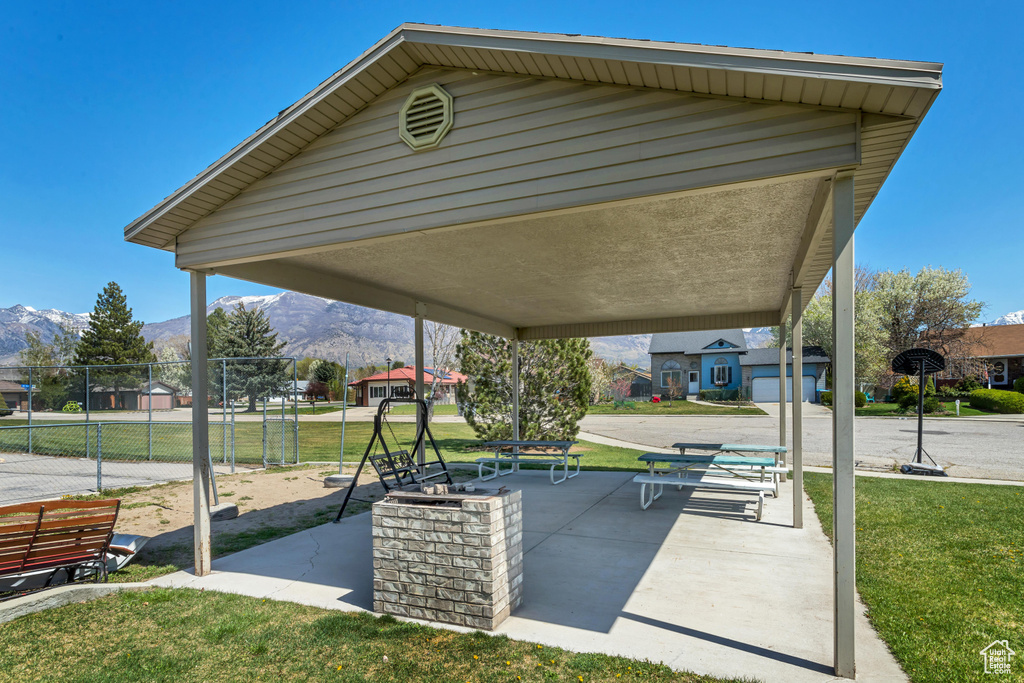View of property\'s community with a mountain view, a playground, and a lawn