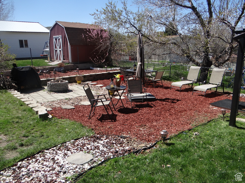 View of yard with a patio, an outdoor fire pit, and a storage unit