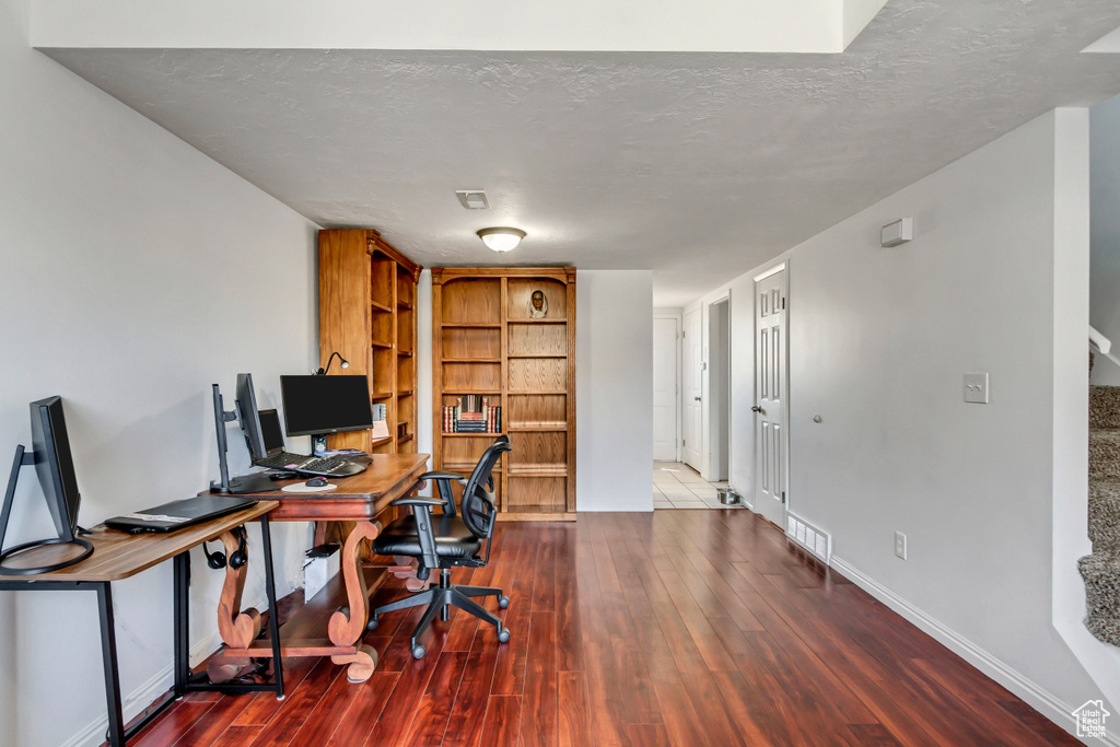 Office space featuring dark hardwood / wood-style floors and a textured ceiling