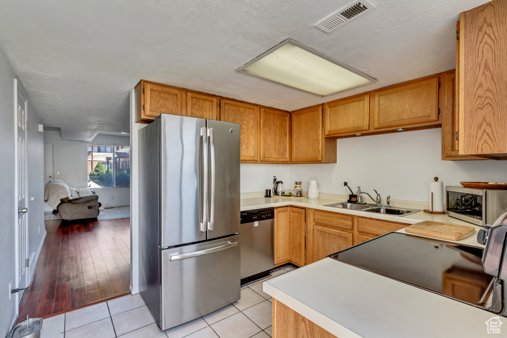 Kitchen featuring sink, stainless steel appliances, and light tile floors