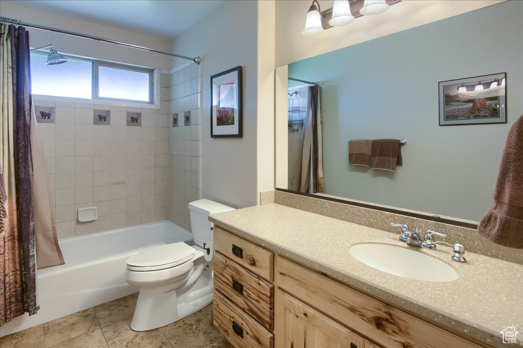 Full bathroom featuring large vanity, shower / tub combo, toilet, and tile flooring
