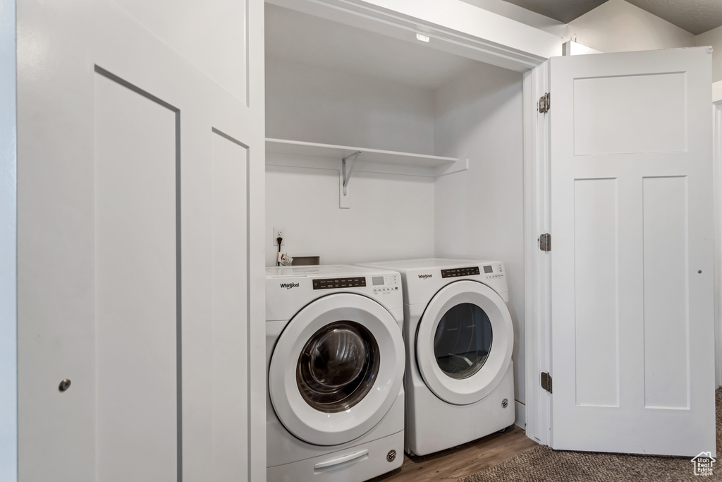 Washroom with independent washer and dryer, washer hookup, and dark wood-type flooring
