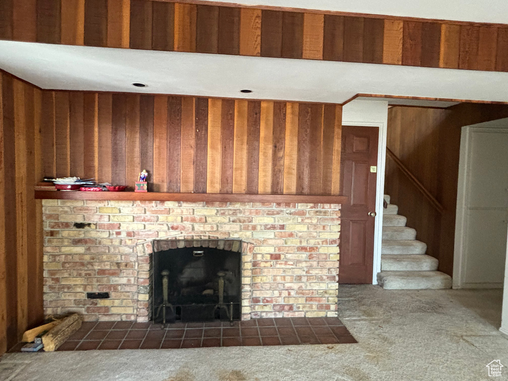 Interior space featuring wood walls, dark carpet, and a fireplace