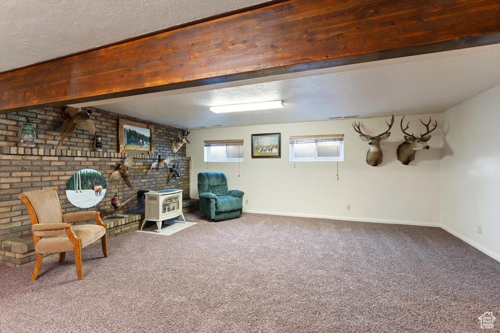 Unfurnished room with a textured ceiling, a wood stove, and carpet flooring