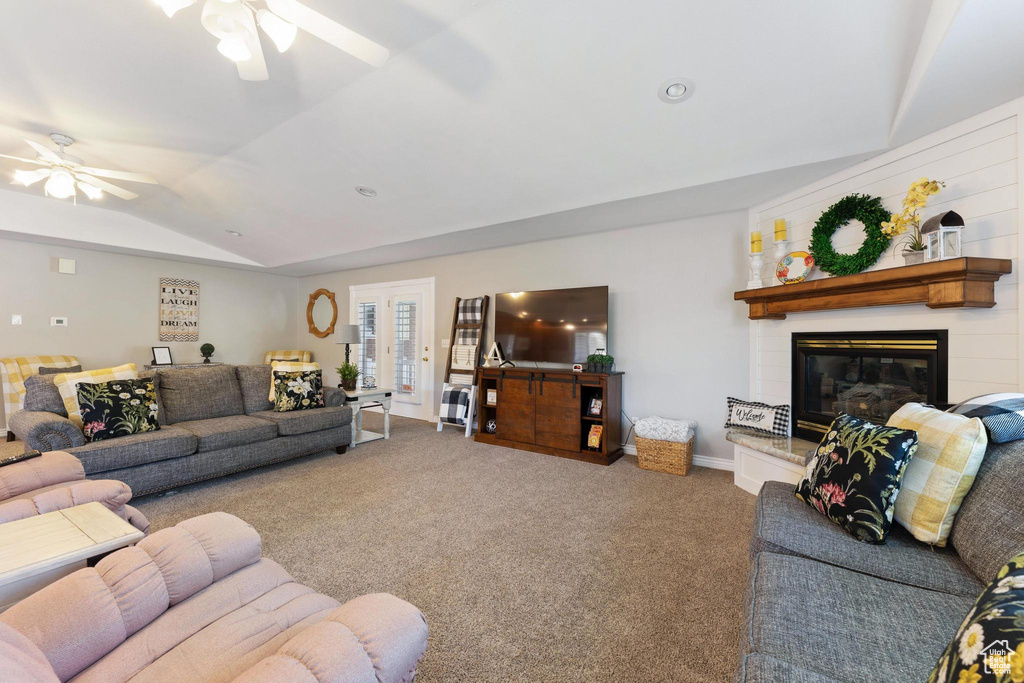 Living room with vaulted ceiling, ceiling fan, and carpet floors