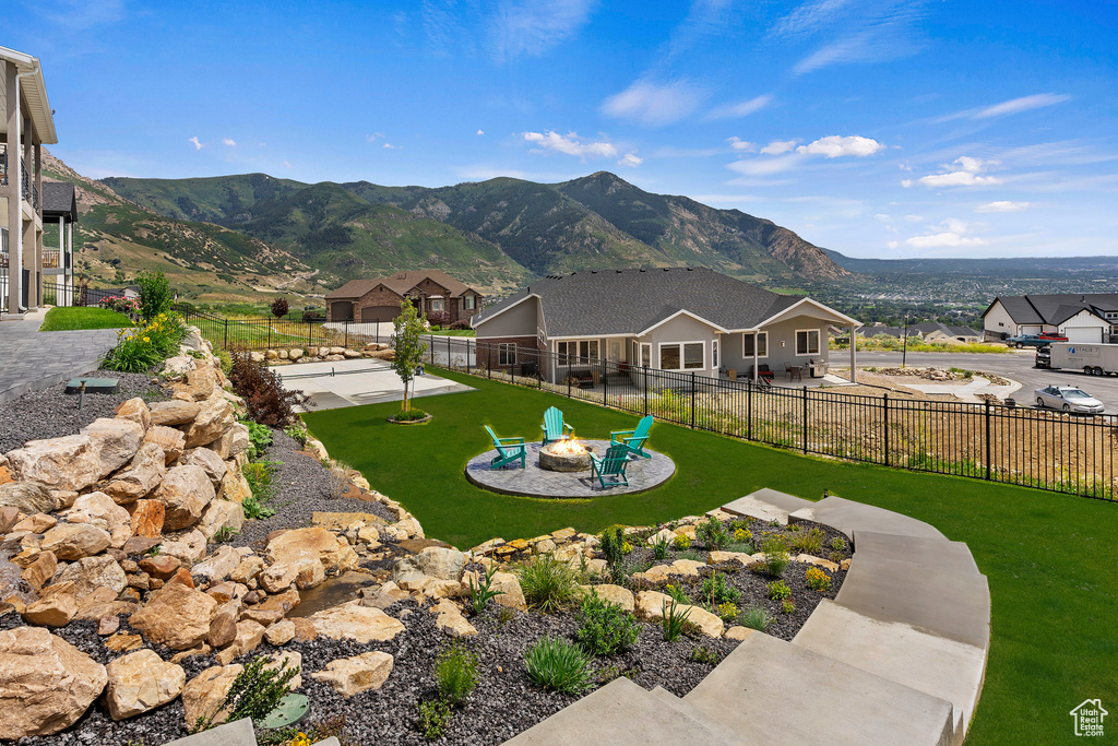 Exterior space with a patio, a mountain view, an outdoor fire pit, and a lawn