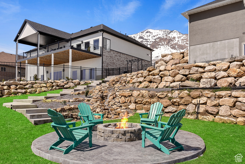Exterior space featuring a mountain view and an outdoor fire pit