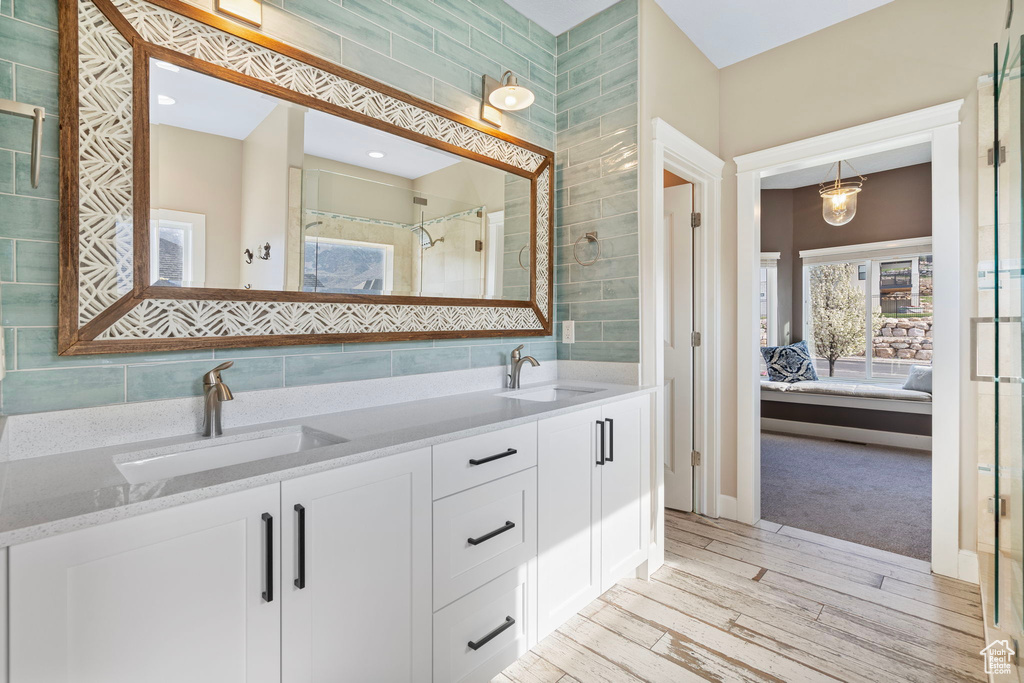 Bathroom featuring tile walls, tasteful backsplash, and double sink vanity