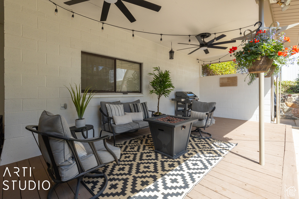 View of terrace featuring a deck, ceiling fan, and an outdoor living space with a fire pit