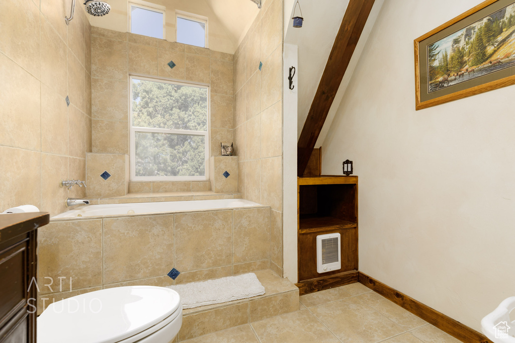 Full bathroom with lofted ceiling with beams, tile floors, vanity, toilet, and independent shower and bath