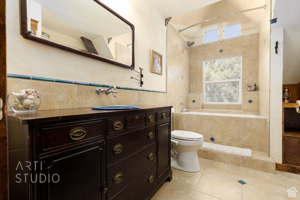 Bathroom with vanity, tile walls, tile flooring, tasteful backsplash, and toilet