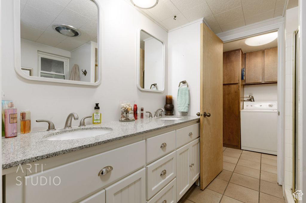 Bathroom featuring tile flooring, double vanity, and washer / clothes dryer