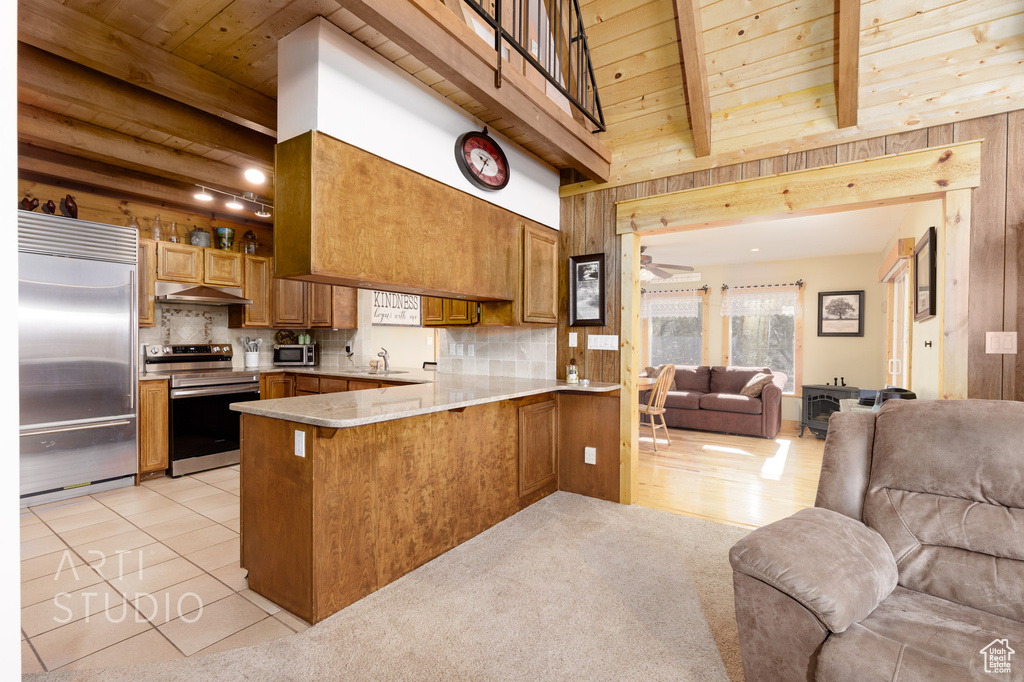 Kitchen with tasteful backsplash, beam ceiling, stainless steel appliances, wooden ceiling, and kitchen peninsula