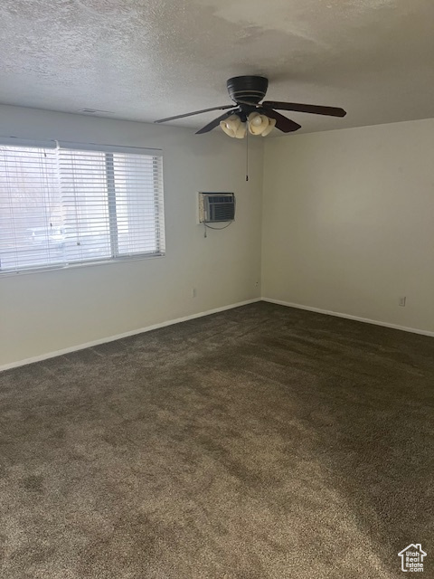 Unfurnished room with a textured ceiling, a wall mounted AC, ceiling fan, and dark colored carpet