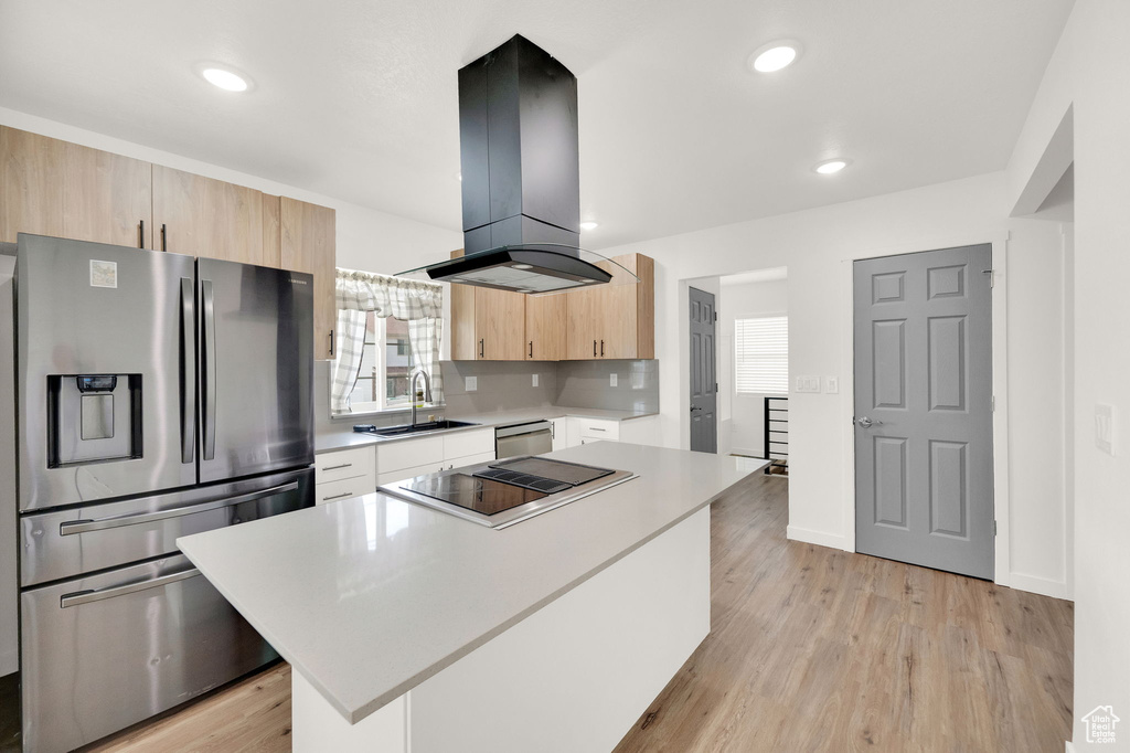 Kitchen with a center island, appliances with stainless steel finishes, light hardwood / wood-style floors, and island range hood