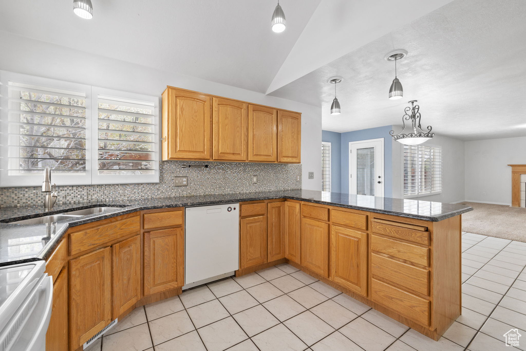 Kitchen featuring backsplash, sink, white dishwasher, and light tile flooring