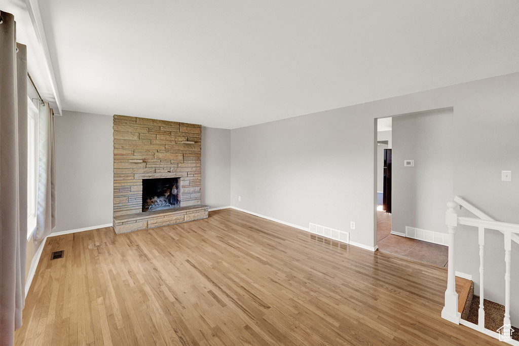 Unfurnished living room with light wood-type flooring and a fireplace