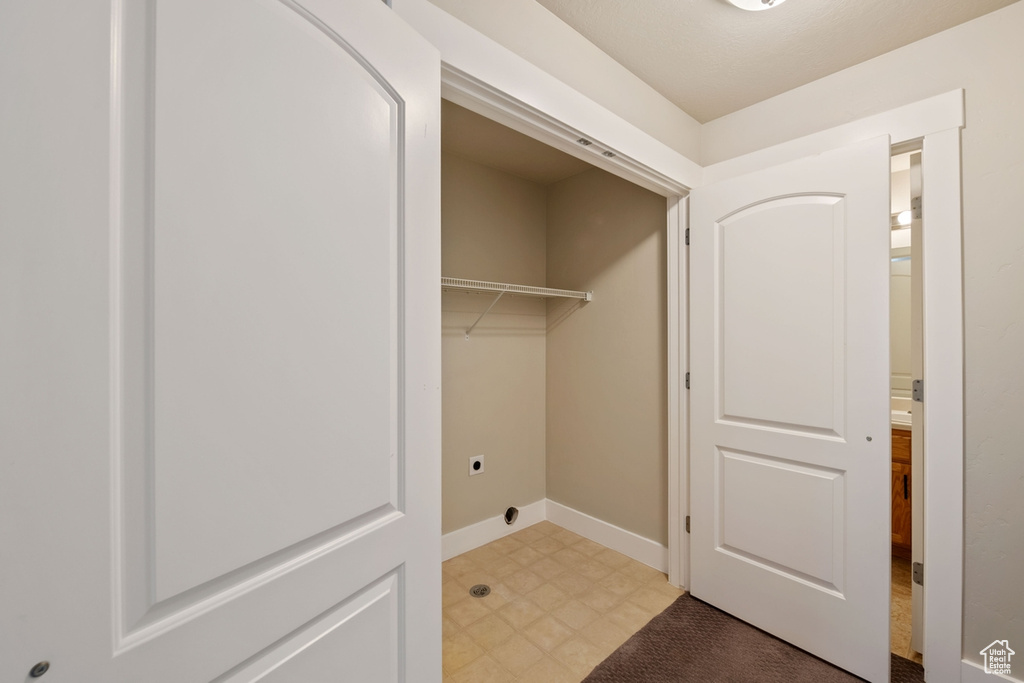 Washroom featuring hookup for an electric dryer and light tile floors