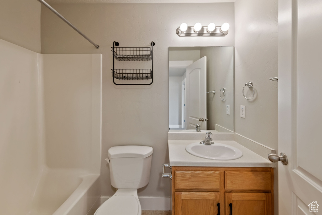Full bathroom featuring vanity with extensive cabinet space, toilet, and bathtub / shower combination