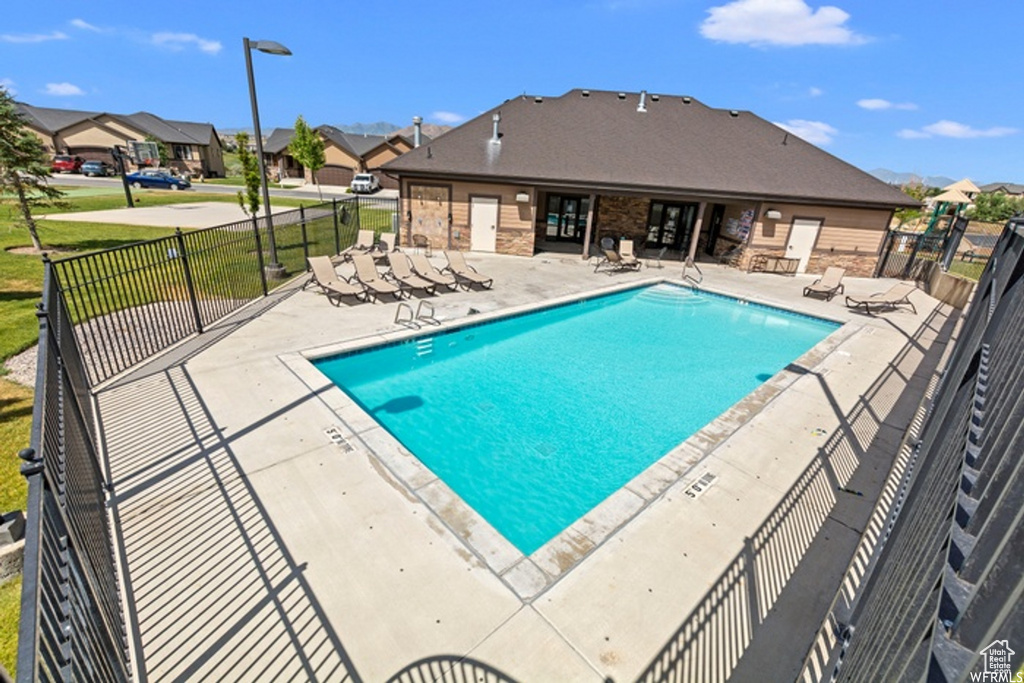 View of swimming pool with a patio area and a lawn