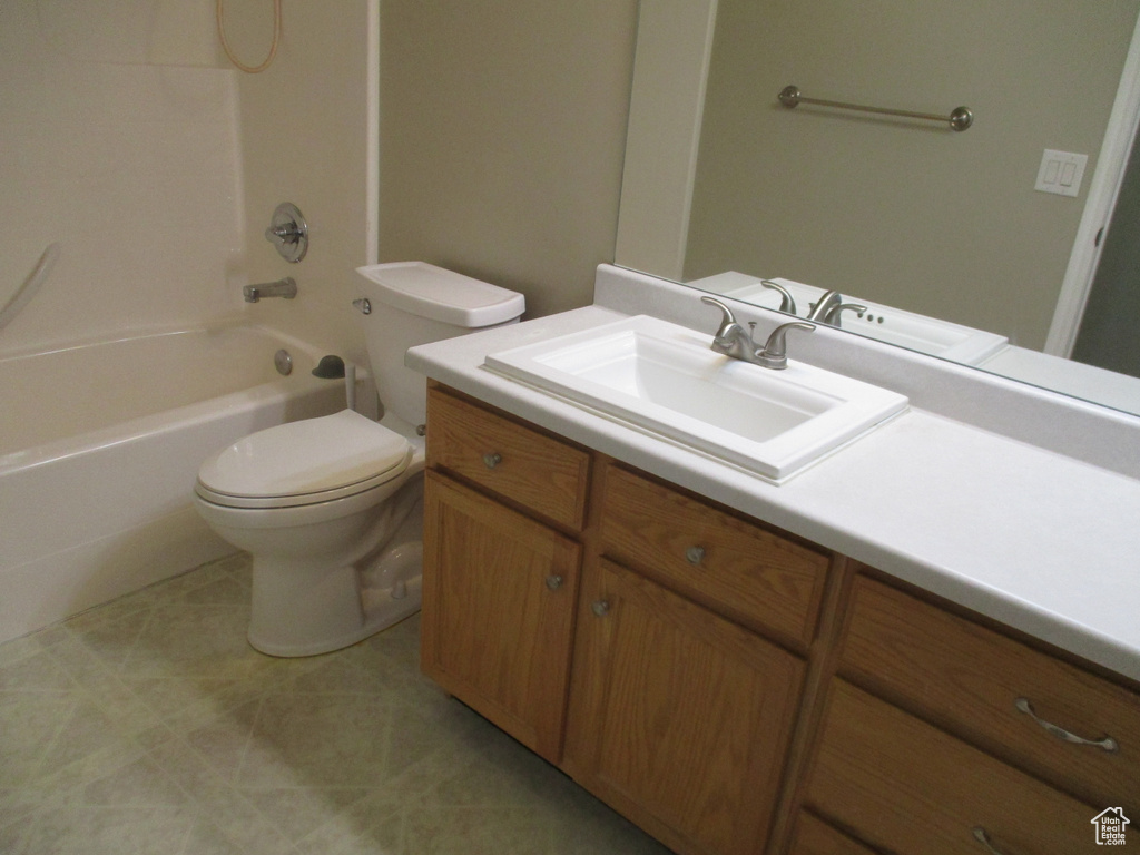 Full bathroom featuring tile floors, vanity, tub / shower combination, and toilet