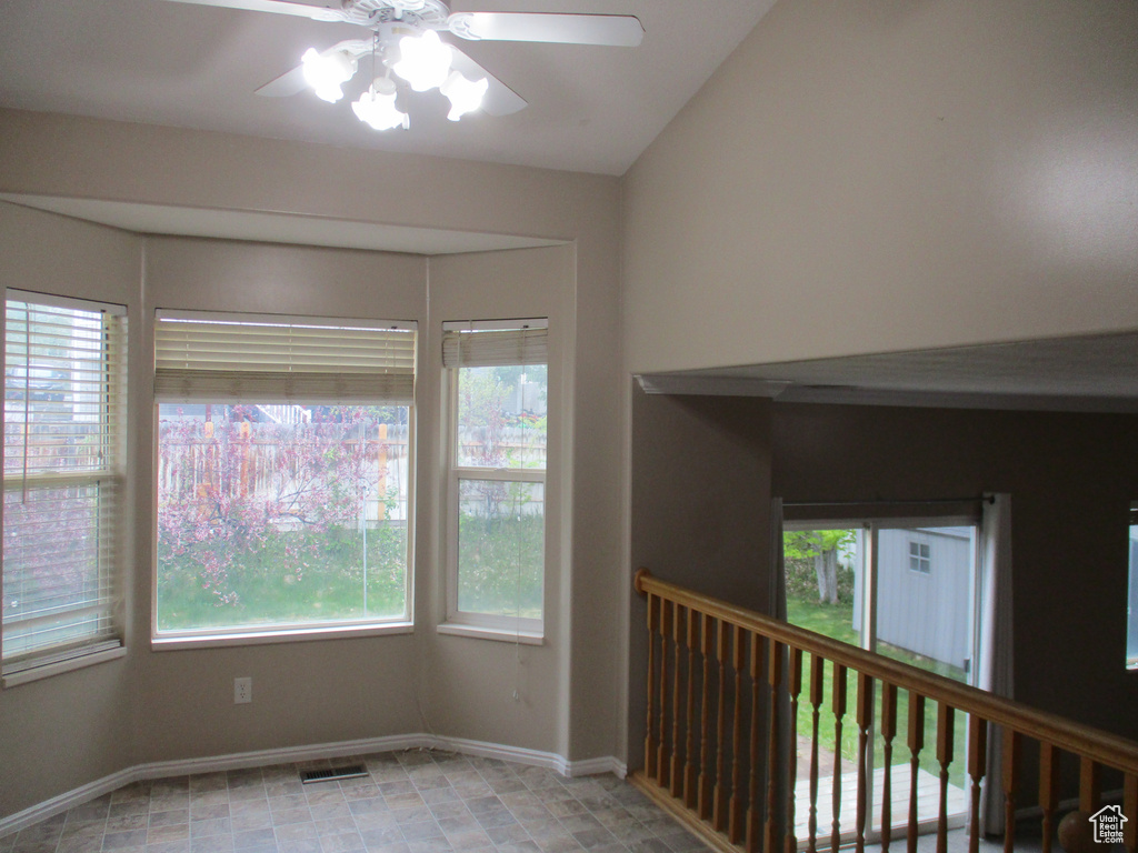 Unfurnished room featuring ceiling fan and vaulted ceiling