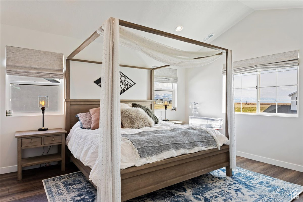 Bedroom with dark hardwood / wood-style flooring and lofted ceiling