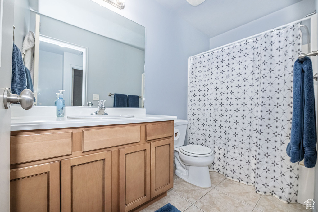 Bathroom with oversized vanity, toilet, and tile floors