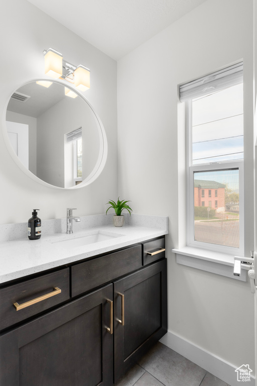 Bathroom featuring a wealth of natural light, tile floors, and oversized vanity